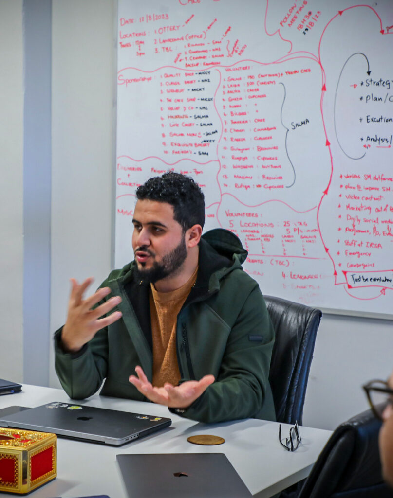 This is a pic of Ayman Abdelhady sitting in a meeting explaining the importance of system processes in marketing